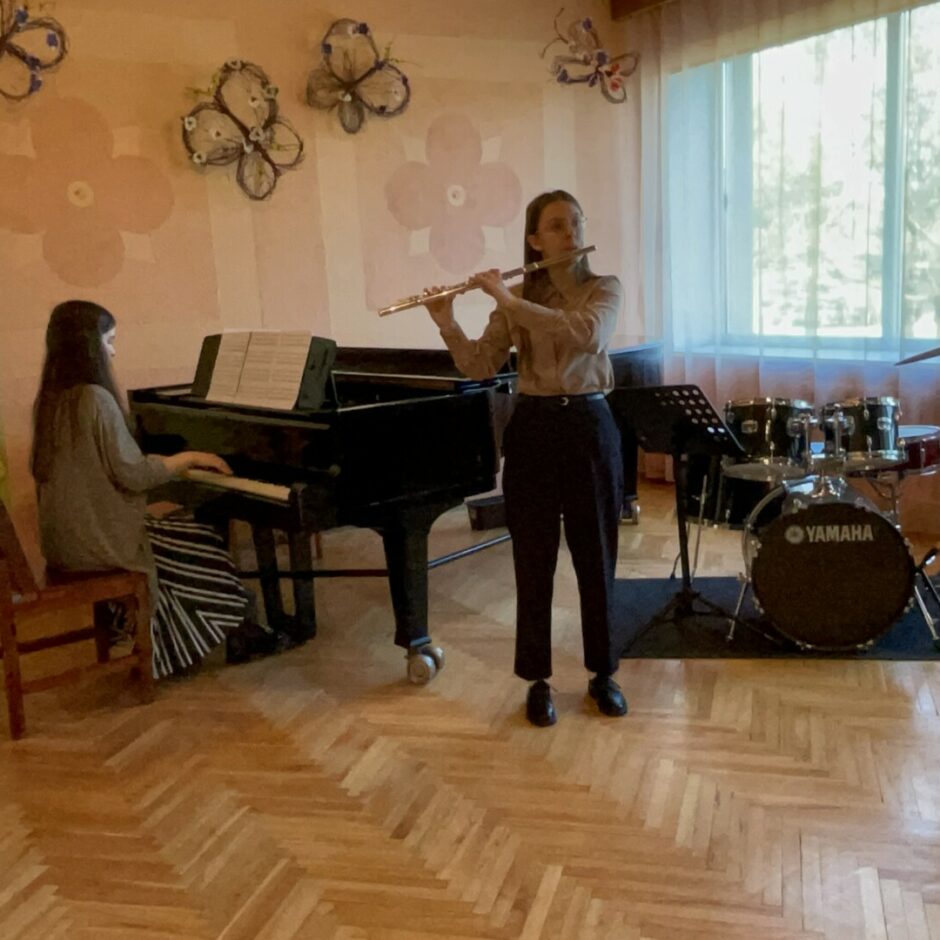 Audzēkņu vakarā audzēkne spēlē flautu