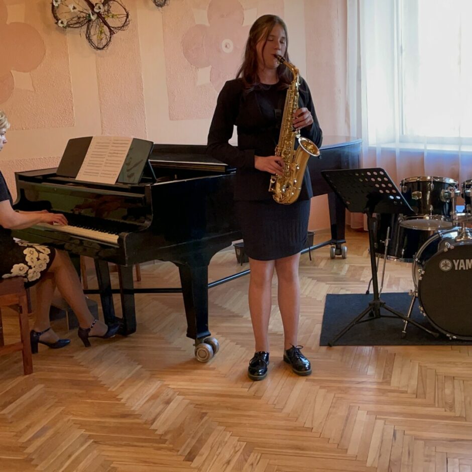 Audzēkņu vakarā audzēkne spēlē saksofonu