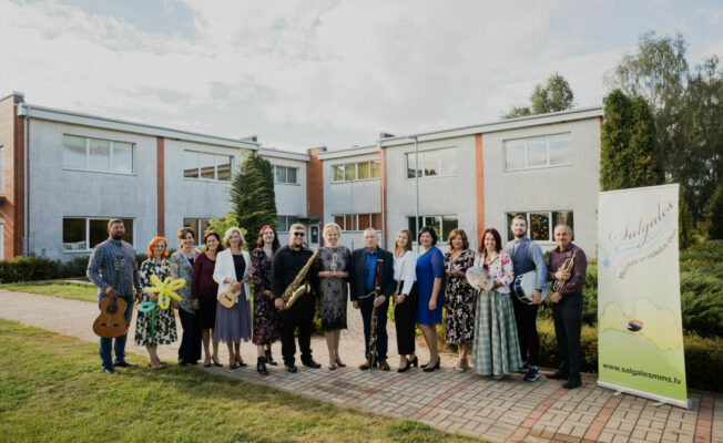 Skolotāju kopbilde ārā pie skolas ēkas