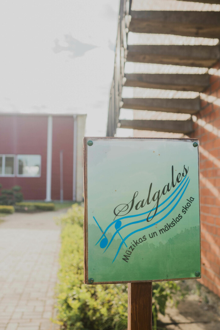 Skolas logo ārā pie skolas ēkas