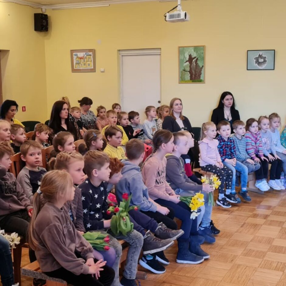 Atvērto durvju dienas dalībnieki klausās koncertu skolas zēlē