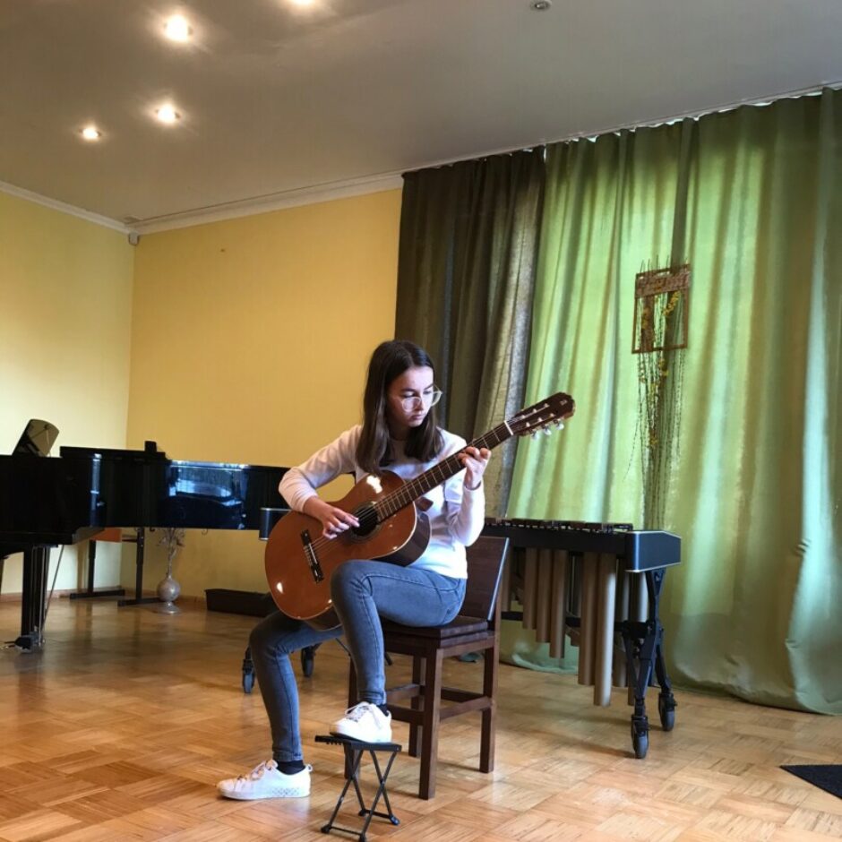 Atvērto durvju dienas koncertā uztājas meitene ar ģitāru