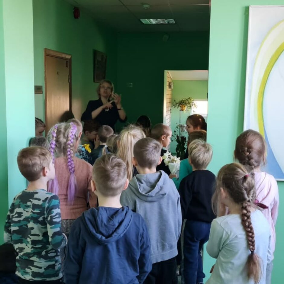 Atvērto durvju dienas dalībnieki gaitenī klausās direktorē