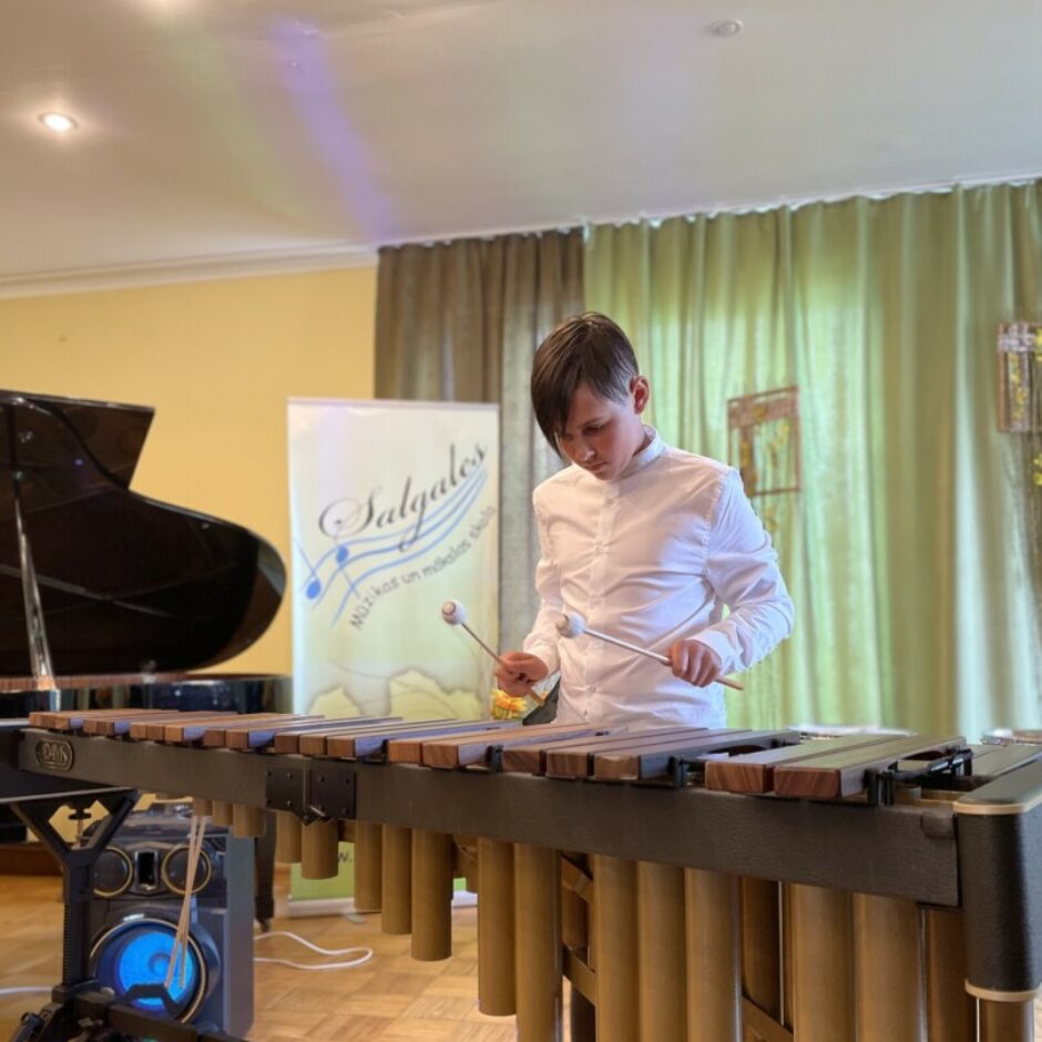 Sitaminstrumentu spēles audzēknis spēlē marimbu koncertā