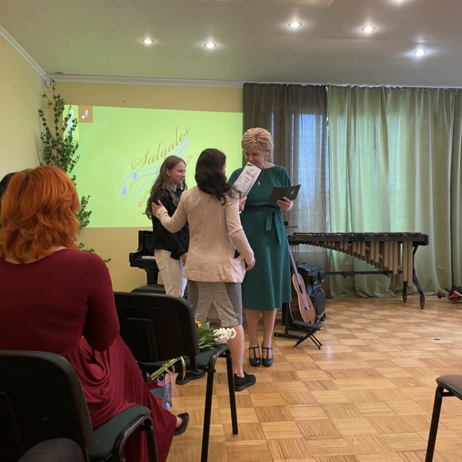 Direktore sveic flautas spēles absolventi un ģimeni izlaidumā