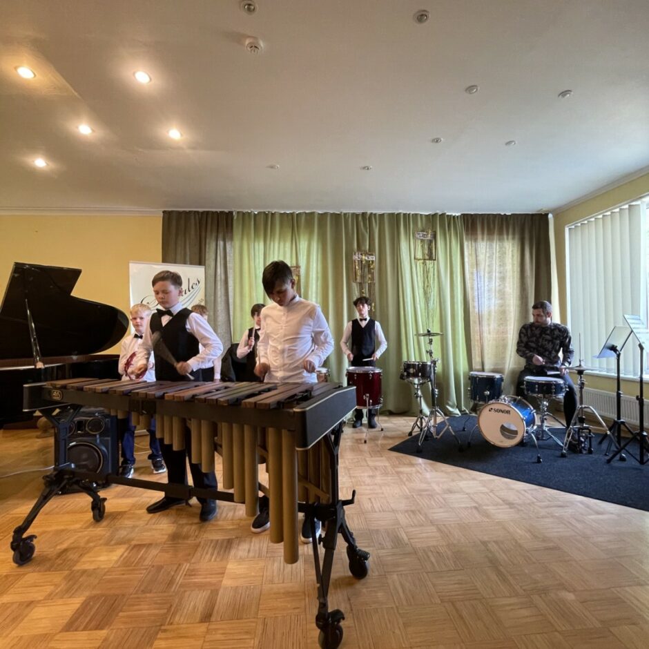 Sitaminstrumentu spēles ansamblis spēlē koncertā