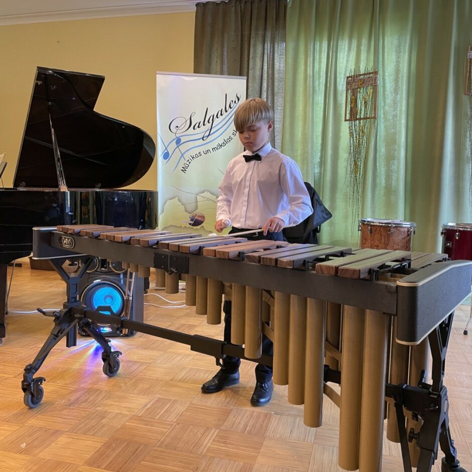 Sitaminstrumentu spēles audzēknis spēlē marimbu koncertā