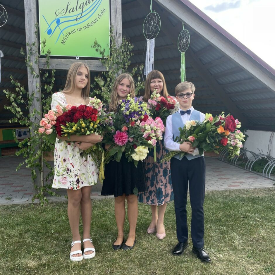 Klavierspēles absolventu un skolotājas kopbilde izlaidumā