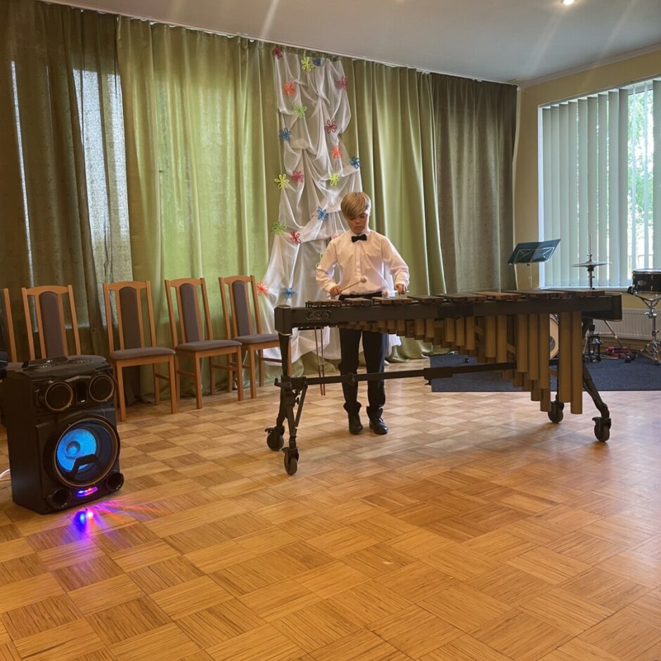 Uzstājas sitaminstrumentu spēles audzēknis, spēlējot marimbu, SMMS mācību gada noslēguma koncertā