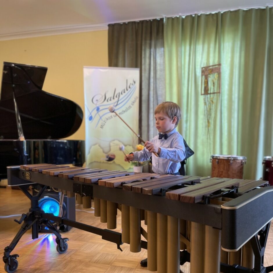 Sitaminstrumentu spēles audzēknis spēlē marimbu koncertā