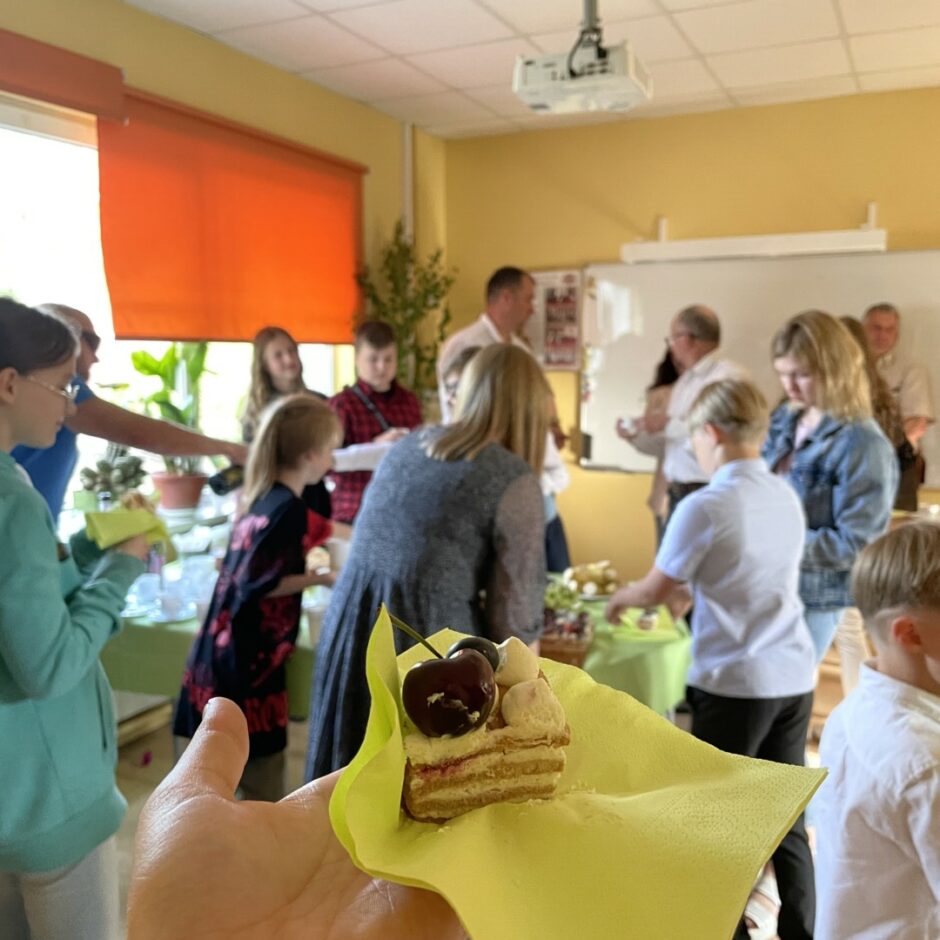 Pēc izlaiduma banketā, kūkas gabaliņš un fonā cilvēki