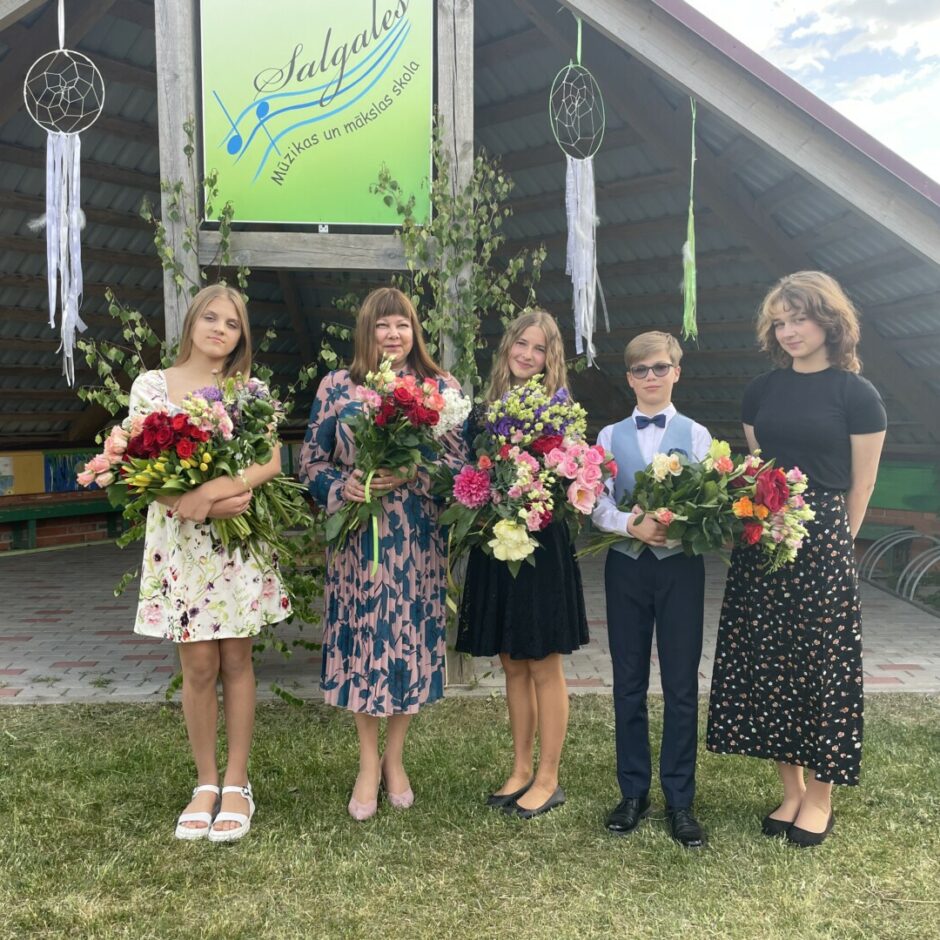 Klavierspēles absolventu un skolotājas kopbilde