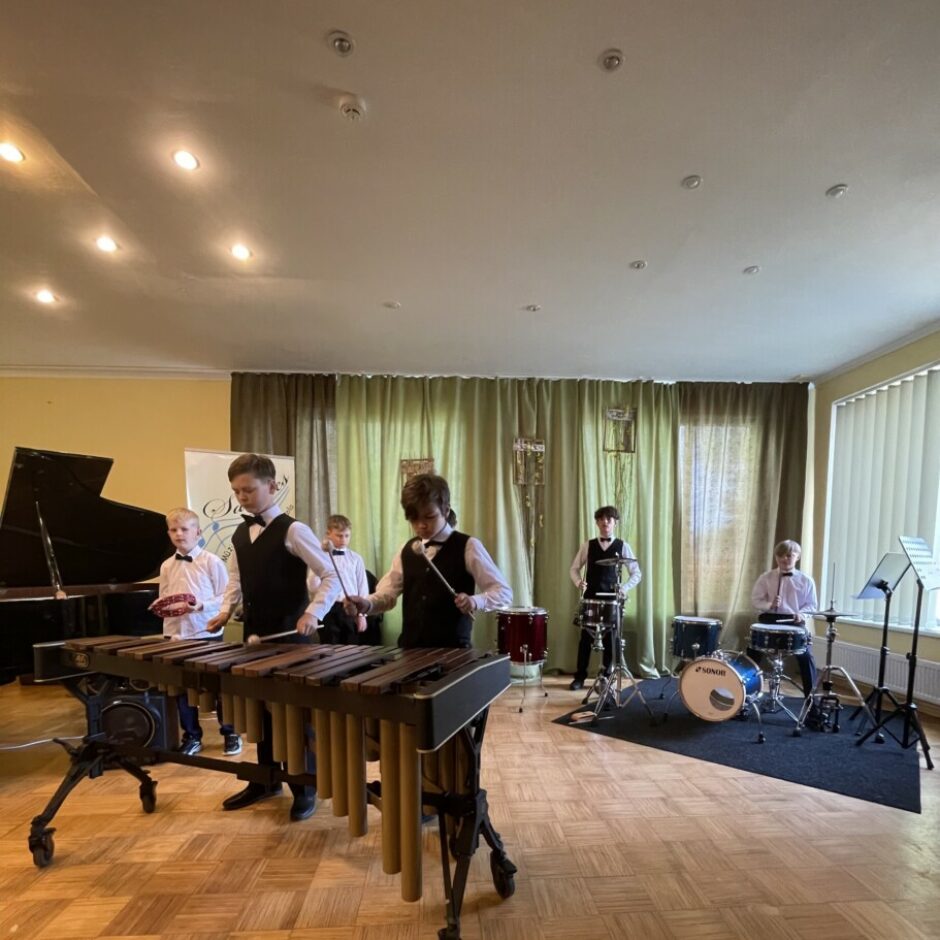 Sitaminstrumentu spēles ansamblis spēlē koncertā