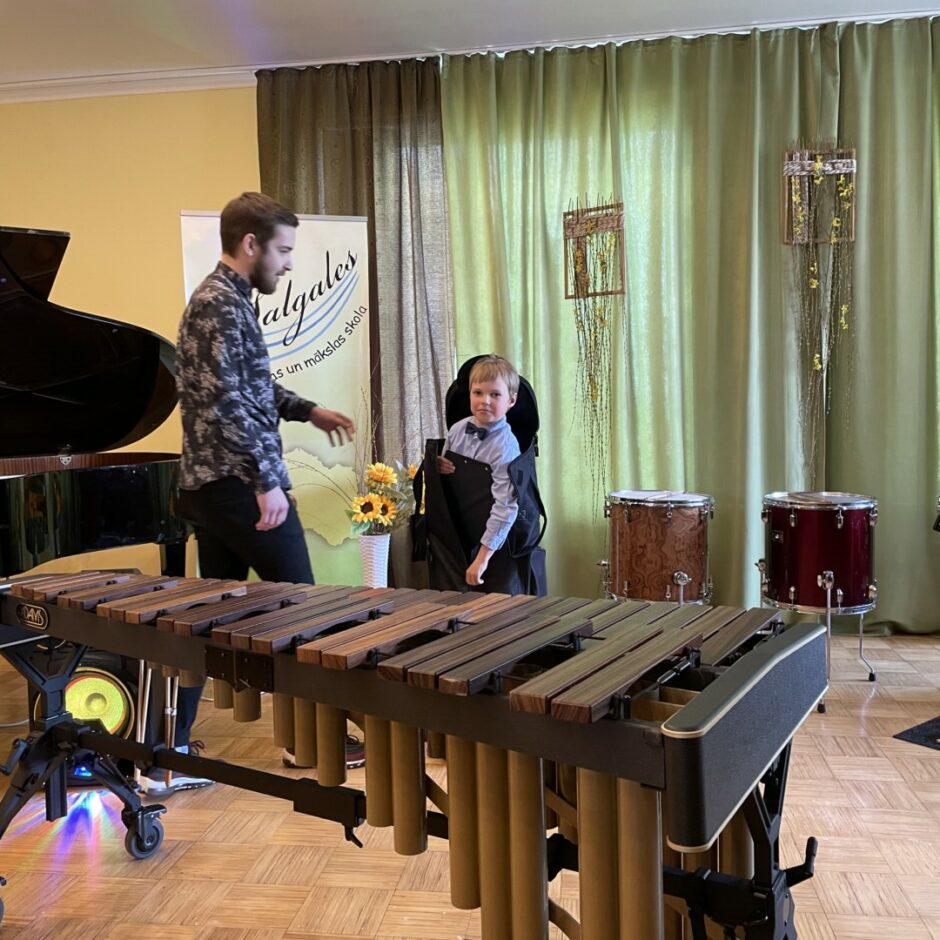 Koncerta atklāšanā no somas izkāpj pirmais koncerta dalībnieks, skolotājs palīdz