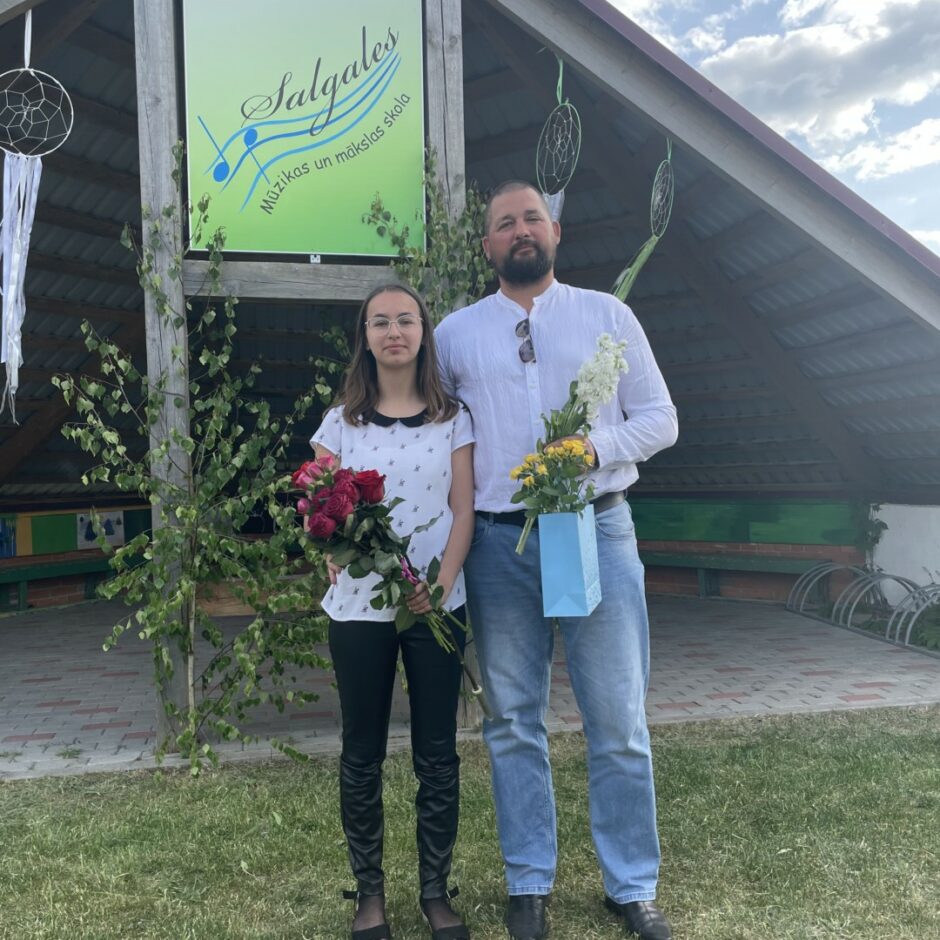 Ģitāras spēles pedagogs ar absolventi izlaidumā