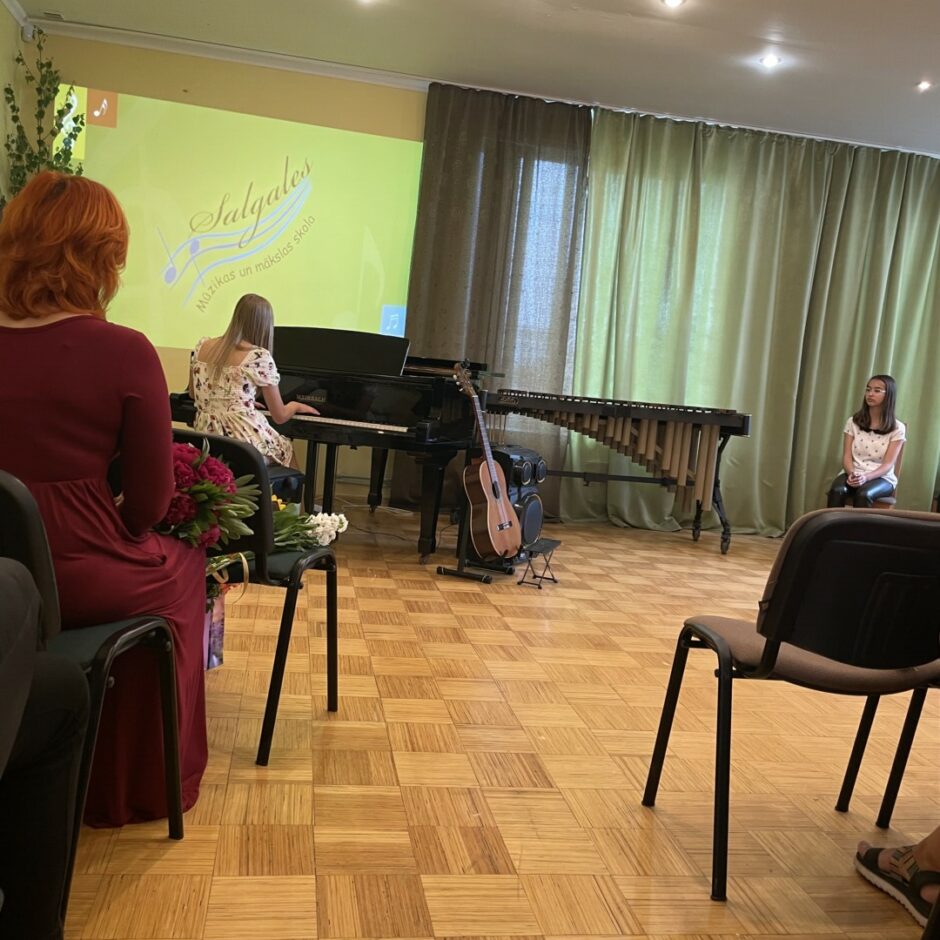 Klavierspēles absolvente spēlē klavieres izlaidumā