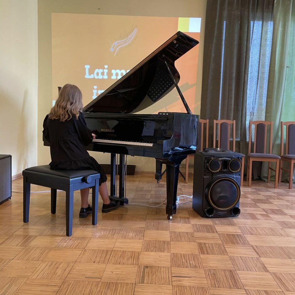 Skolniece spēlē klavieres SMMS mācību gada noslēguma koncertā