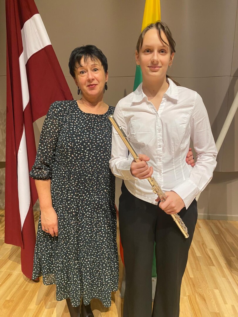 Jauna sieviete smaidot tur galda spēli ar vāku, uz kura redzams teksts 